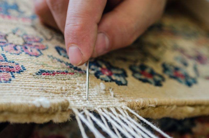 L’aiguille passe entre les chaînes : chaque frange est nouée, jamais collée.