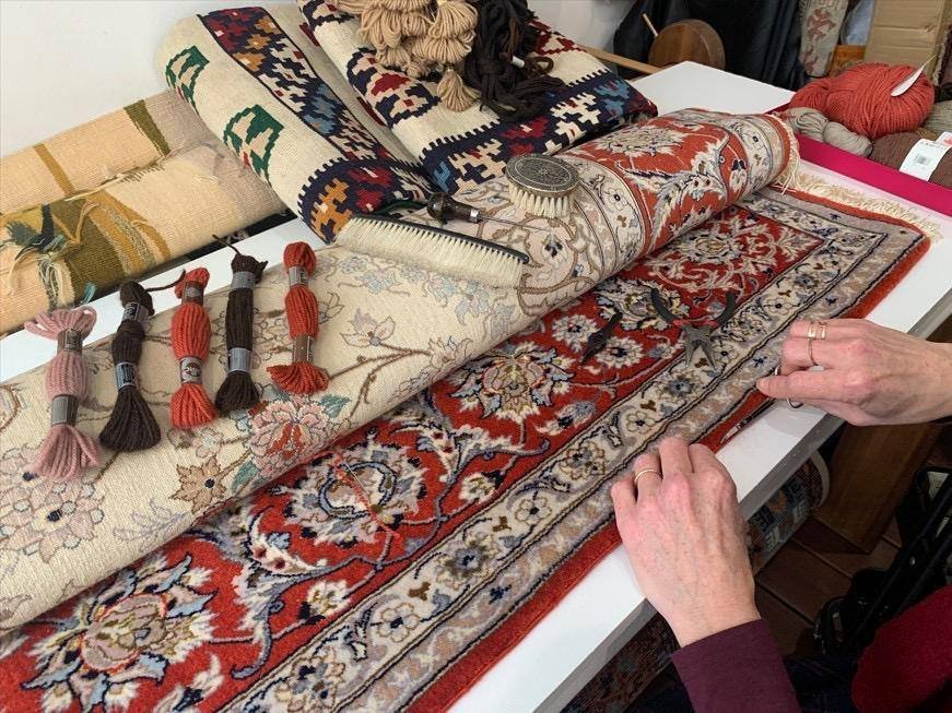 L’établi : écheveaux de laine classés par teinte, brosse et ciseaux de tondeur.