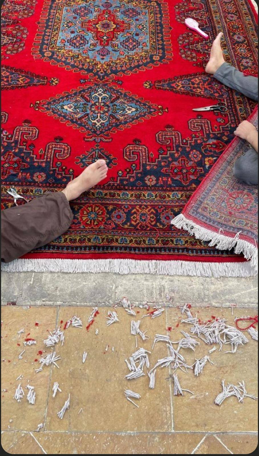 Égalisation des franges d’un grand tapis, une fois la greffe terminée.