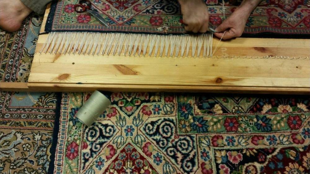 La planche à clous : les chaînes des franges sont tendues une à une avant nouage.